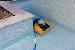 Dolphin W20 robotic pool cleaner in action at a swimming pool.