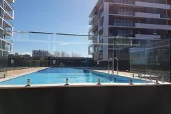 Pool at Crown Street Wollongong with modern high-rise buildings in the background.